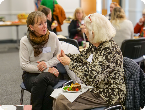 Two women talking to each other at an event