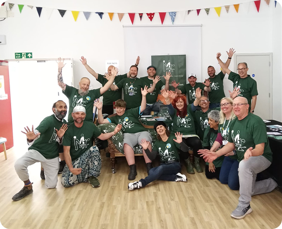 The Mr Hastings & St Leonards team sit in a group waving their hands in the air