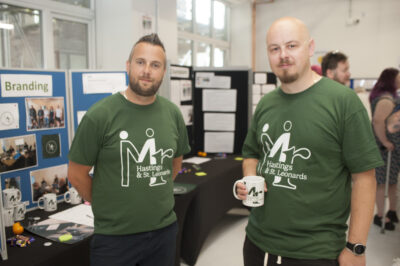 Two men having a cup of tea at their exhibition stand for Mr Hastings & St Leonards