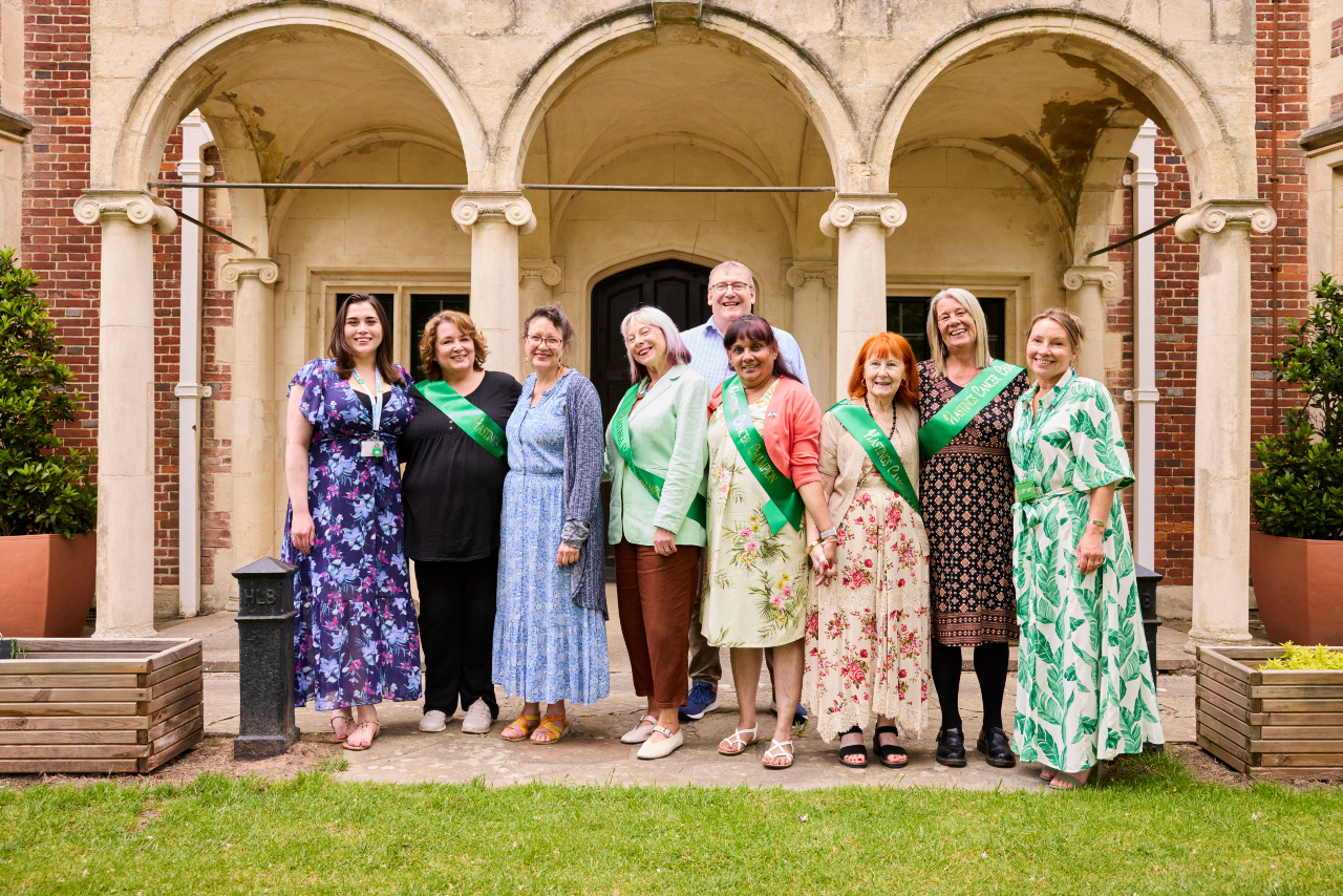 Hastings Cancer Support Champions stand in a row wearing green sashs