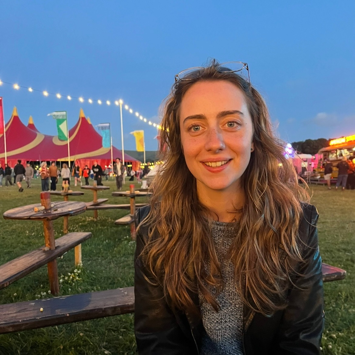 Phoenix Boyle with tents behind her, smiling at the camera