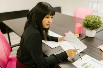 A woman holds a pen and piece of paper with a graph on it