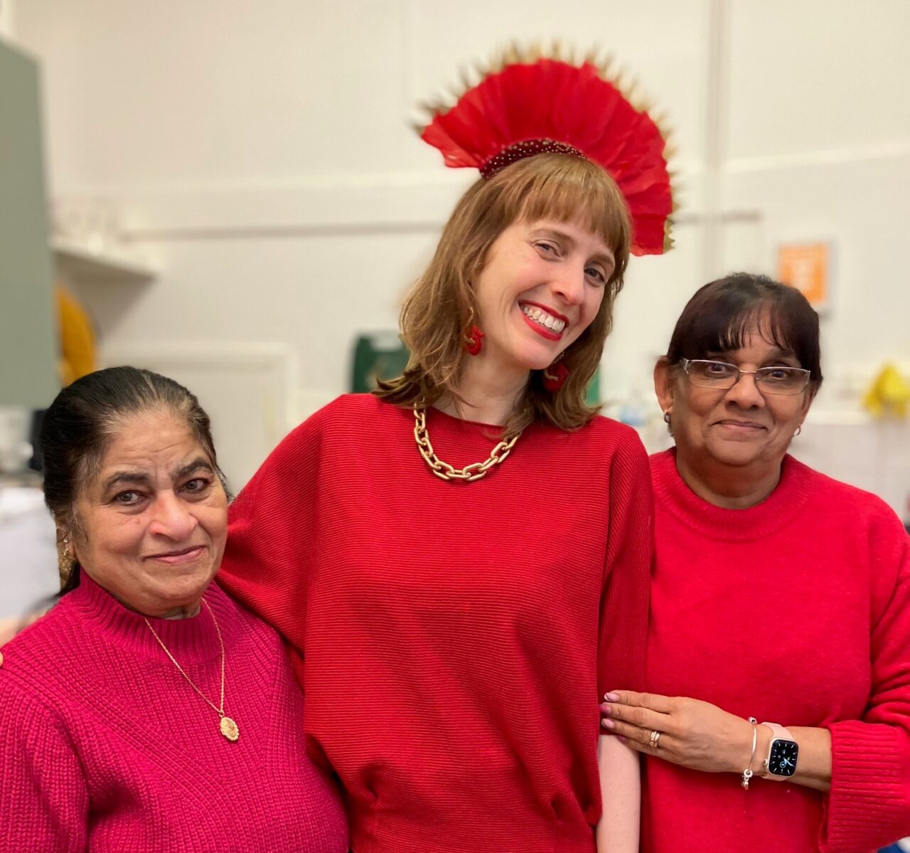 HVA staff member and members of the community smiling dressed in red