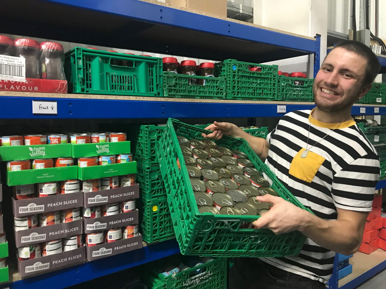 A foodbank volunteer carrying a box
